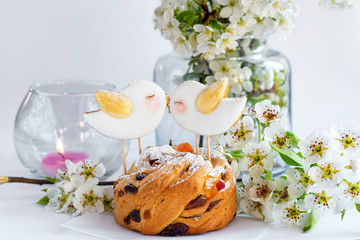 Cupcake with gingerbread in the form of spring birds on top. Bird love. Spring arrangement with cherry blossom.