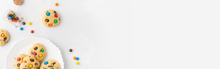 Bakery, confectionery banner. Sweet cookies with colorful candies for children on white background. Top view, copy space. Children menu, Recipe