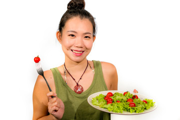 young happy and beautiful Asian Chinese woman holding dish with green lettuce and tomato salad smiling cheerful in diet and weight loss through healthy natural nutrition