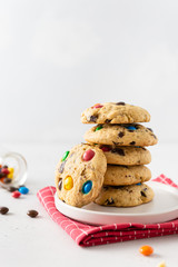 Stack of Homemade vanilla cookies decorated with multi-colored candy drops on white background. Side view, close up