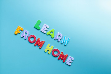 Text LEARN FROM HOME of wooden letters on background with copy space