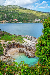 Beautiful landscape – sea lagoon with turquoise calm water, stones and rocks on the beach, blue...