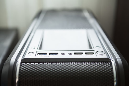Black pc tower case with usb connection sockets, power and reset buttons, close up view