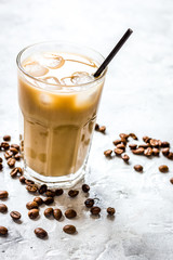 cold coffee glass with ice cubes on stone table background