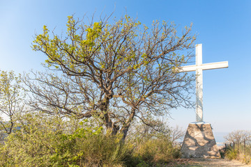 Christian crucifix on the hills over San Benedetto del Tronto, Marche , Italy. Pier in background with blue Adriatic sea