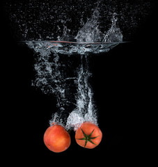 Tomatoes falling into the water