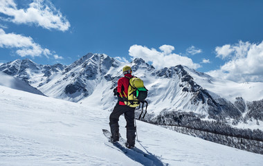 Fototapeta na wymiar Active man with backpack ski touring at mountains background in Caucasus, Russia
