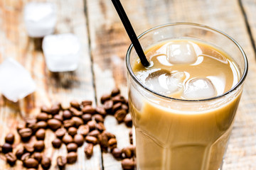 Ice coffee with milk and beans for lunch on wooden background
