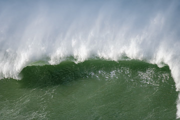 Naklejka premium A big wave crashing in the coast. Plenty of blank space.