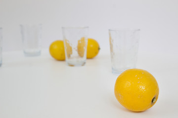 Still life with yellow lemons and glasses on white background home creative cuisine healthy food lifestyle concept