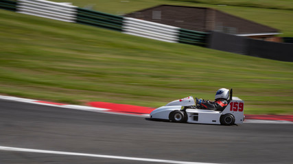 A panning shot of a white racing go-kart.