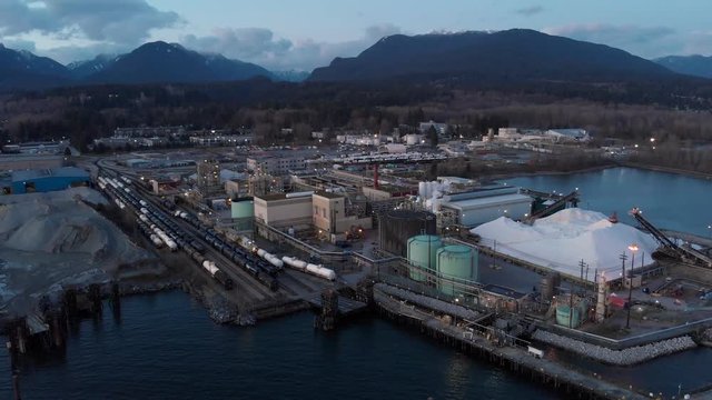 Aerial drone footage of a industrial shipyard and cargo ship loading port in Vancouver, BC, Canada. 4K 24FPS.