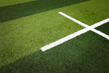 Fototapeta premium White stripe on the green soccer field from top view