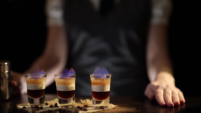 Bartender serving B52 cocktails on fire