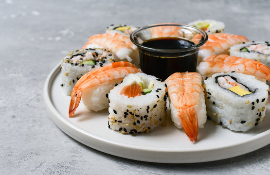 food delivery set of sushi and rolls with salmon and shrimp on the light background, selective focus image. service food order online. 