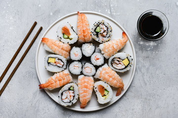 food delivery set of sushi and rolls with salmon and shrimp on the light background, selective focus image. service food order online. 
