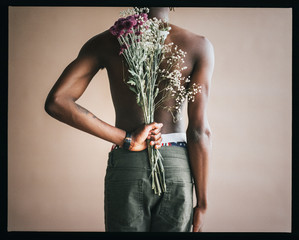 Black male model with flowers in a studio photoshoot