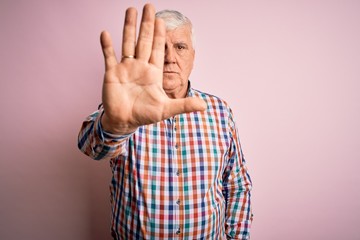 Senior handsome hoary man wearing casual colorful shirt over isolated pink background doing stop...