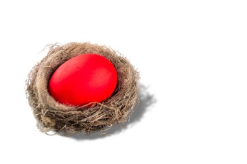 Red Egg Inside Its Nest On A Wooden Table