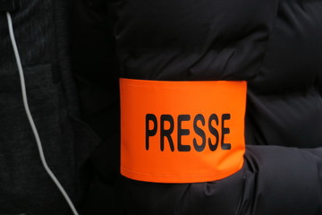 Brassard Presse, lettres noires sur fond orange.