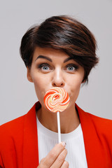 Studio portrait of woman holding colorful lollipop