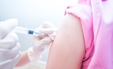 Naklejka premium Doctor or nurses hand are adult vaccination to patient using the syringe injected upper arm for treated,Doctor giving an injection to a patient,Prophylactic HPV vaccin, flu, covid-19 and anal cancer.