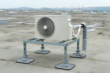 Flat warehouse roof with mounted air conditioning on legs used for cooling offices