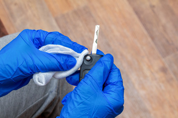 cleaning, disinfecting, wiping auto keys panel with a hand in glove and napkin close up