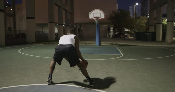 Man playing basketball at night