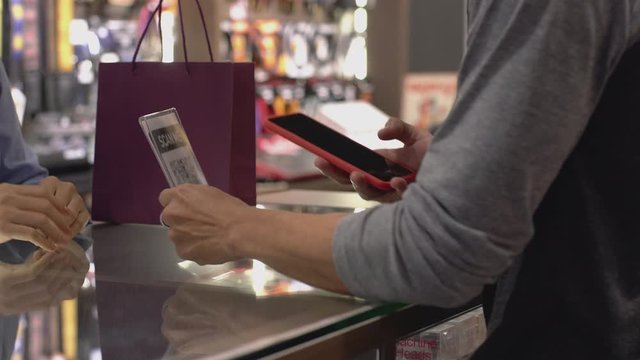 An upwardly mobile Asian Muslim man using a mobile phone to scan the QR Code to pay for a product at a sale terminal identification payment for verification and authentication