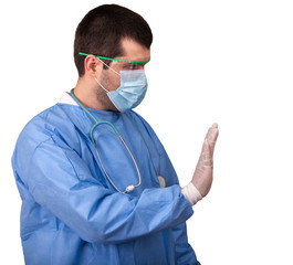 Doctor in surgical gown with stethoscope, mask and goggles against coronavirus which shows the stop sign, isolated on white background. Concept of stop the spread of covid-19