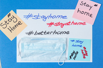 hashtag stay home lettering on paper with medical mask and copy space