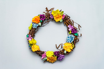 Spring composition of a wreath of birch branches and craft colorful flowers