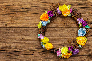 Spring composition of a wreath of birch branches and craft colorful flowers