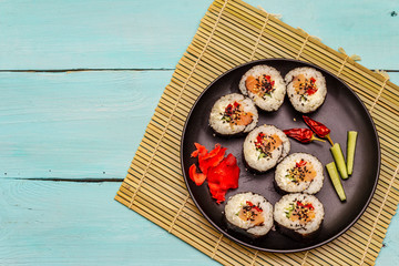 Korean roll Gimbap(kimbob). Steamed white rice (bap) and various other ingredients. Trendy turquoise background