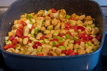 Picture of the frying colourful meal in the pan close up. Background of the colourful frying meal pattern close up.