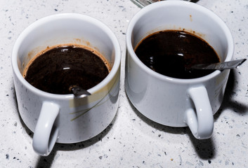 Two white cups of coffee top view on white background.