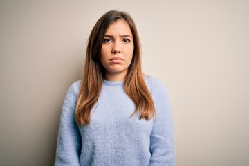 Beautiful young woman wearing casual winter sweater standing over isolated background depressed and...