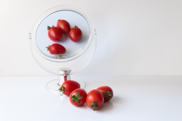 Tomato reflection in the mirror on a white background