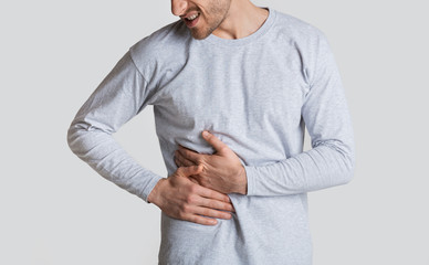 Liver disease concept. Man presses hands to his side