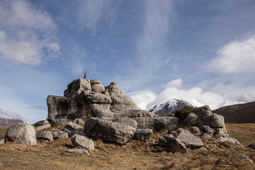A person standing on a rocky hill in New Zealand