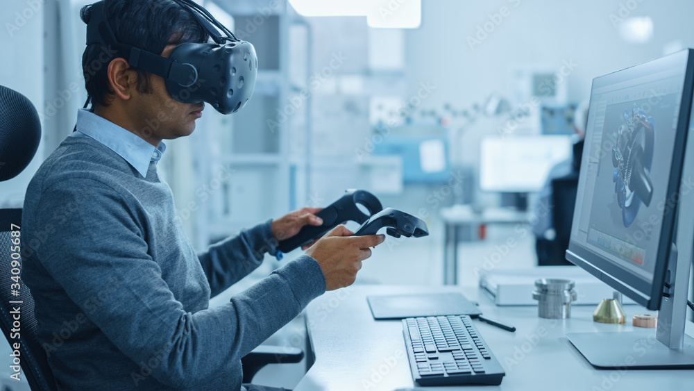Poster Modern Industrial Factory: Mechanical Engineer Wearing Virtual Reality Headset, Holding Controllers, Uses VR technology for Industrial Design, Development and Prototyping in CAD Software on Computer.