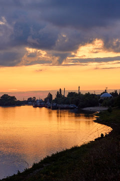Colorful clouds at sunset over the river in the town © watcherfox