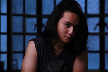 Portrait of an Asian teenager with long hair.