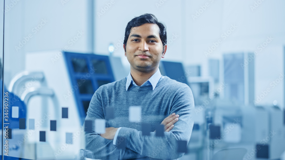 Poster modern factory office: portrait of handsome indian engineer crosses arms and smiles charmingly. in t