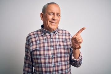 Senior handsome man  wearing casual shirt standing over isolated white background with a big smile on face, pointing with hand and finger to the side looking at the camera.