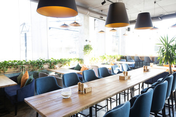 Light modern interior of urban restaurant or cafe with dining places