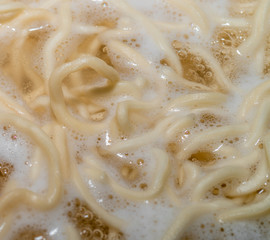 Homemade noodles are boiling in a pot. Close-up macro photo noodles.  While boiling, the smoke of the noodles comes out. © ErdalIslak