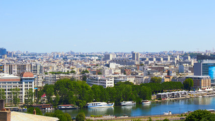 Fototapeta na wymiar Paris, France - August 26, 2019: Paris from above showcasing the capital city's rooftops, the Eiffel Tower, Paris tree-lined avenues with their haussmannian buildings and Montparnasse tower. 16th
