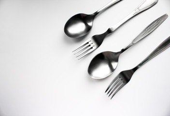 Fototapeta premium Two spoons and two forks on a white background